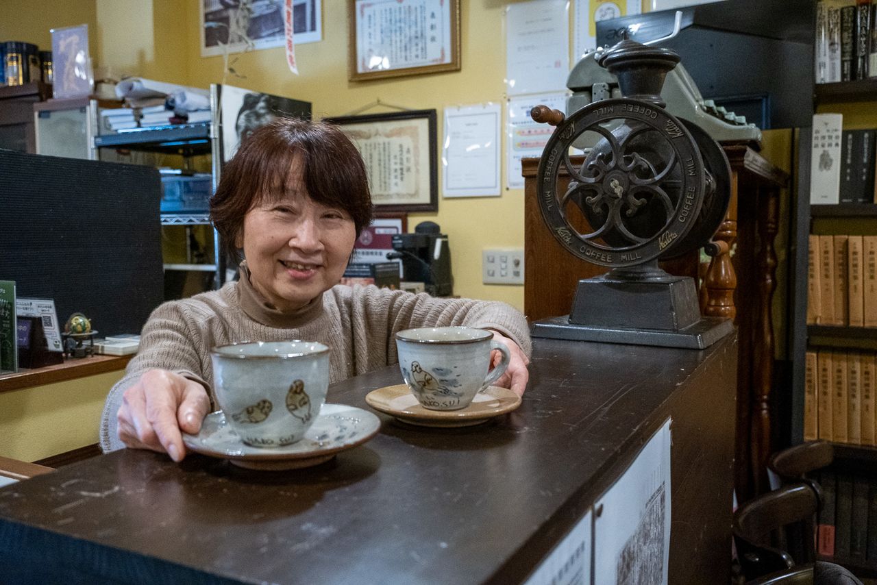 Hanada sostiene tazas originales inspiradas en leones marinos, encargadas a un ceramista. (© Michiko Hayashi)